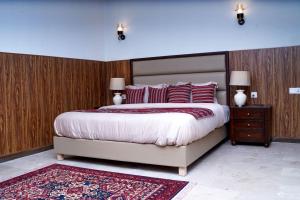 Chhāngla GaliCedar Lodges Resort and Residences Galiyat的一间卧室配有一张带红色枕头的大床