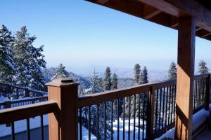 Chhāngla GaliCedar Lodges Resort and Residences Galiyat的从雪地小屋的甲板上欣赏美景