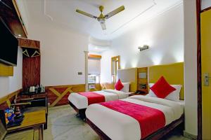 新德里Hotel Cottage Yes Please - New Delhi的酒店客房设有两张床和电视。
