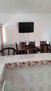 蒙特里科Casa de Descanso en Monterrico的用餐室配有桌椅和平面电视。