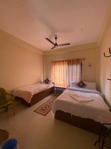 索拉哈Hotel BhupuSainik Sauraha的带窗户的客房内的两张床