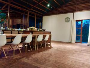 SaonekVilla Luzo的一间带桌子和白色椅子的用餐室