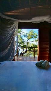 SaonekVilla Luzo的一间卧室设有一张床,窗户有树