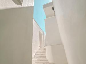 图兰克Perios Beach House - Adults Only的白色建筑中白色墙壁的楼梯