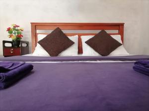 埃拉Opal Cottage Ella的一张大床,配有紫色床单和枕头