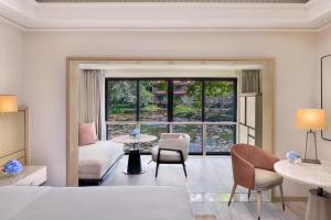 卡乌罗西姆The St. Regis Goa Resort的卧室配有一张床和一张桌子及椅子