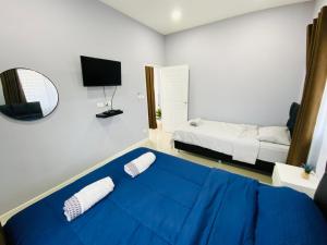 梭桃邑Patteera Pool Villa Sattahip的一间卧室配有蓝色的床和镜子