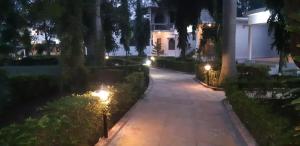 克久拉霍The Baagh Jungle Resort的夜间在房子前面的走道