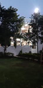 克久拉霍The Baagh Jungle Resort的前面有树木的白色大建筑