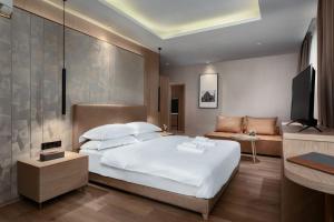 金边SF HOTEL Penthouse Residences的卧室配有一张白色的大床和一张沙发。