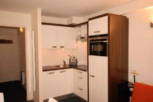 古雷特Résidence MARMOTTES - Studio pour 4 Personnes 004的小厨房配有白色橱柜和冰箱。