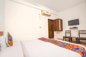阿格拉FabHotel Sai Residency的卧室配有白色的床和电视