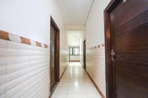 阿格拉FabHotel Sai Residency的一条空的走廊,有木墙和门