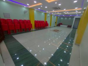 蒂鲁瓦纳马莱Pushpa Mahal A/C & Pushpa Residency的一间空房间,配有红色椅子和白色地板