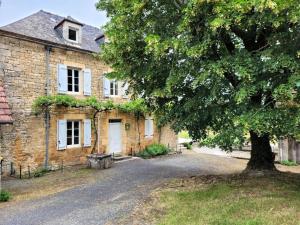 Gîte de France De baudran 3 épis - Gîte de France 6 personnes 424的一座古老的砖房,前面有一棵树