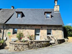 埃格勒通Gîte de France à Chapelle-Spinasse 3 épis - Gîte de France 4 personnes 104的一座古老的石头房子,前面有鲜花