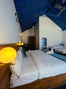 奇克马格尔Shree Kalya Resort- Chikmagalur的卧室配有一张白色大床和蓝色天花板