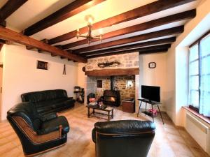 Gîte de France à Montaignac sur Doustre 2 épis - Gîte de France 6 person 584的客厅配有皮革家具和壁炉