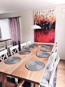 萨伦Joängets Fjällgård 18a的一张带白色椅子的长木桌子和一幅画
