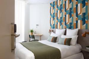 昂热Hôtel Suzane的一间卧室配有一张大床和色彩缤纷的床头板