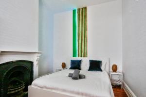 悉尼Family Friendly 3 Bedroom House Glebe 2 E-Bikes Included的卧室配有蓝色和绿色色调的白色床。