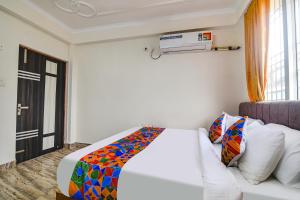 巴特那FabHotel Buddha Sunrise的一间卧室配有一张床、一张沙发和一个窗口