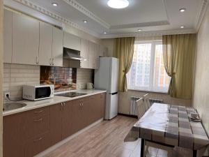 阿拉木图Apartmens in Complex Almaly 83-51的厨房配有白色冰箱和桌子