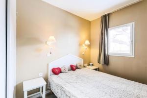 Le DésertRésidence Le Thabor - maeva Home - Appartement 2 Pièces 5 Personnes - Confo 73的一间卧室配有一张带红色枕头的床