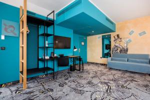 什切青ibis Styles Szczecin Stare Miasto的蓝色的客房配有沙发和书桌