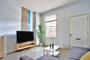 悉尼Charming 2 Bedroom House Surry Hills的客厅配有平面电视和沙发。
