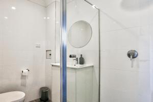 悉尼Charming 2 Bedroom House Surry Hills的带淋浴、水槽和镜子的浴室