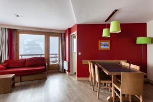 Saint-Bon-TarentaiseRésidence Le Christiana - maeva Home - Appartement 2 Pièces 7 Personnes - S 12的红色的客厅配有红色的沙发和桌子