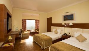 乌提宝石公园乌蒂酒店的酒店客房设有两张床和电视。
