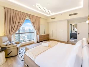 迪拜FAM Living - Stunning 2 Bedroom Home In JBR的一间卧室设有一张大床和一个大窗户