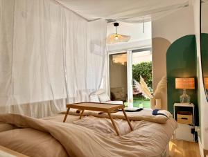 阿格德角Super Mini Loft avec Cinéma et Jardin - Cap d'Agde的卧室配有一张桌子,位于床上