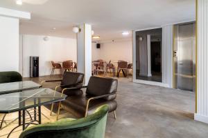 提比里亚Lago Hotel的一间带桌椅的房间和一间用餐室