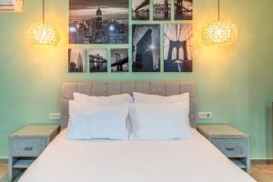 提比里亚Lago Hotel的卧室配有一张四幅画的墙壁床。