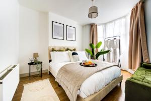 伦敦Heart of Hackney - 2bed garden flat sleeps 6的一间卧室,配有一张床,上面放着一碗水果