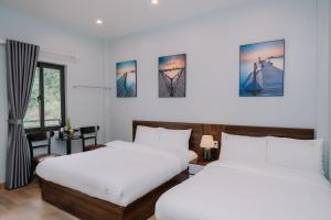 吉婆岛Napoli Hostel的白色墙壁客房的两张床