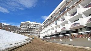 Les PrésRésidence Cortina 2 - Appartements pour 6 Personnes 884的前面有雪的白色大建筑