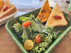春川Chuncheon Diary Stay的绿色的盘子,有沙拉和面包