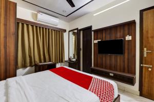 班加罗尔OYO Hotel Golden Residency的一间卧室配有一张床和一台平面电视