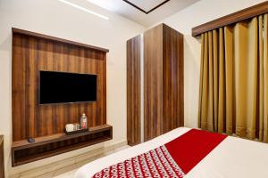 班加罗尔OYO Hotel Golden Residency的一间卧室配有一张床和一台平面电视