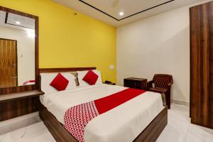 班加罗尔OYO Hotel Golden Residency的一间卧室配有一张大床和一把椅子