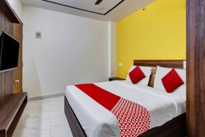 班加罗尔OYO Hotel Golden Residency的一间卧室配有一张带红色枕头的大床