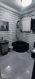 开罗Just A Break - جست بريك لحجز الفنادق的浴室配有黑色浴缸和卫生间。