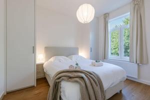 波佩林赫Beautiful vacation home 'Valkehuisje' in Poperinge的卧室配有白色的床和窗户。