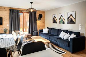 瓦尔莫雷尔CHALET LUMI - Chalet CHALET MAGDALENA pour 6 Personnes 624的客厅配有蓝色的沙发和桌子