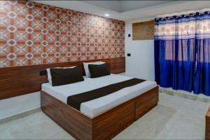 大诺伊达The Simran suites的一间卧室配有一张带蓝色窗帘的大床