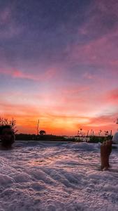 圣玛丽亚德尔法加洛Ciriga Sicily Glamping Resort的一个人在日落时站在水面上
